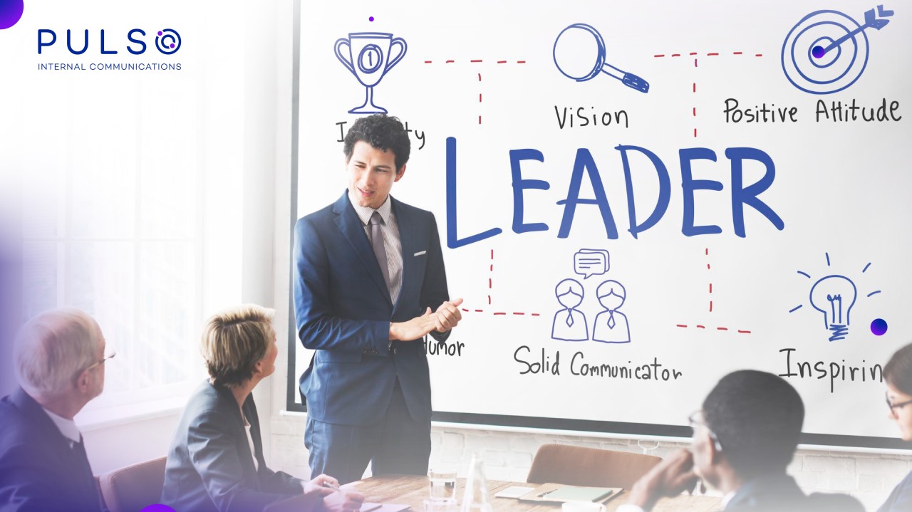 Un líder corporativo de pie exponiendo sobre liderazgo y cultura interna frente a su equipo de trabajo durante una capacitación empresarial.